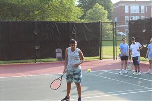 boy hitting a tennis ball with a racket